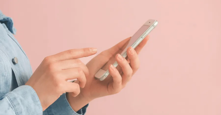 Klarna changes - mobile phone being held against a pink background