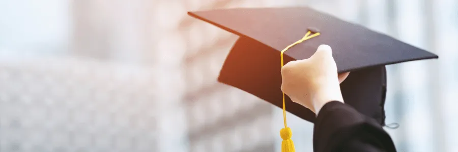 Student debt - student holding graduation cap in the air