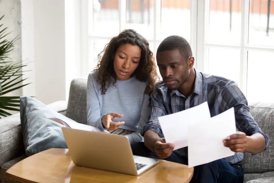 Couple looking at bills and laptop