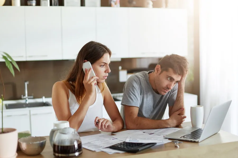 Couple on the phone looking at laptop screen