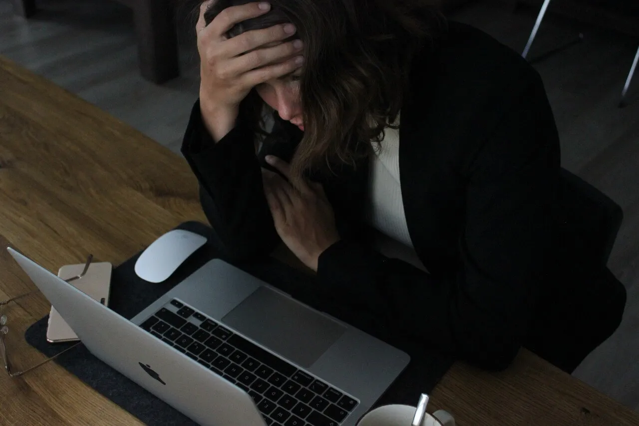 Assess your debts - woman looking stressed at laptop