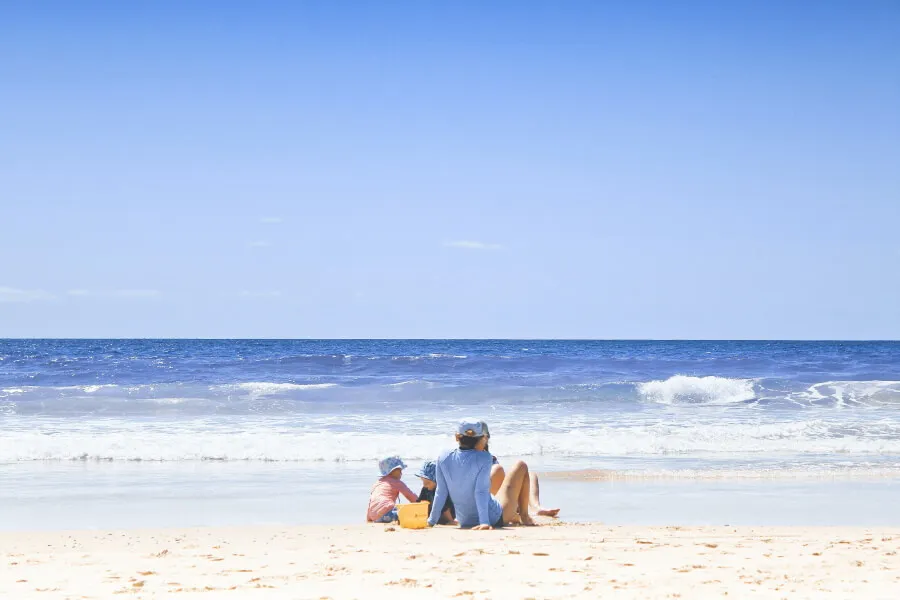 Family sat on a sunny beach