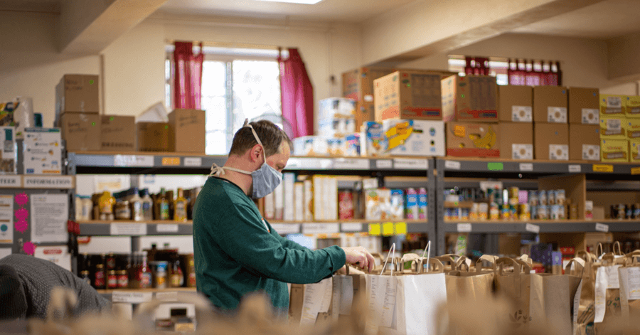 man working in a foodbank wearing a face mask