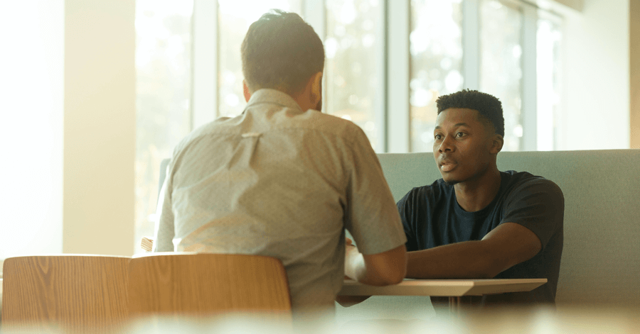 two people talking about debt advice at a table