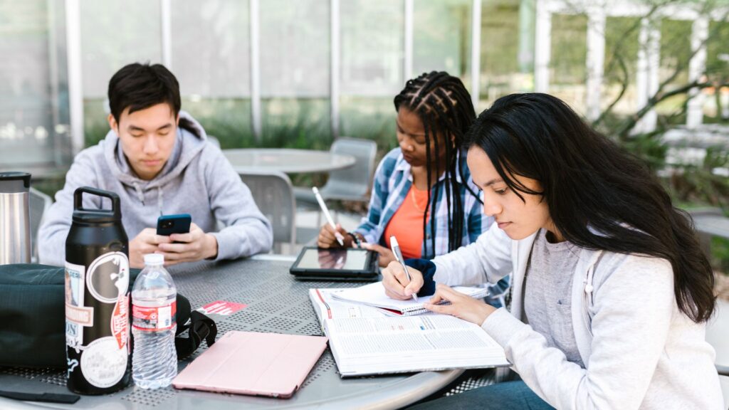 students sat at a desk outside doing work