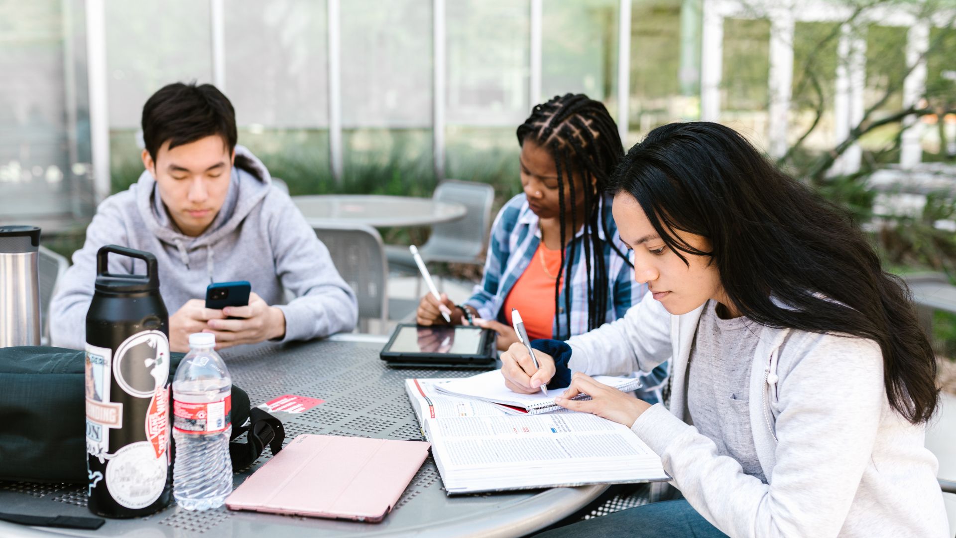 students sat at a desk outside doing work