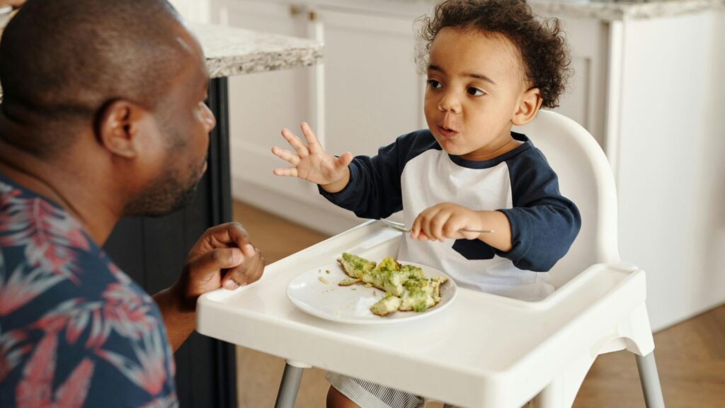 image of a baby in a highchair eating food