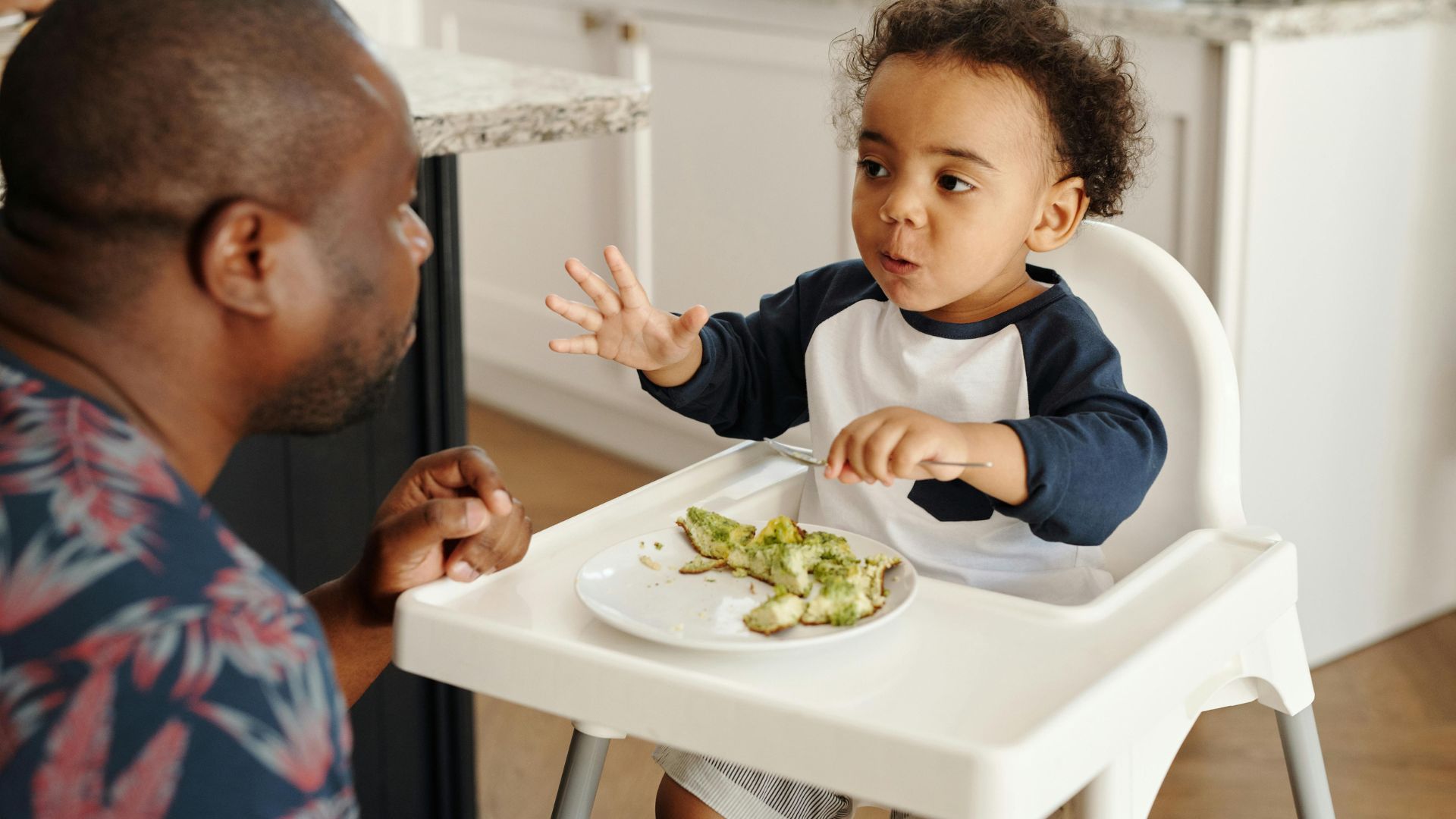 image of a baby in a highchair eating food
