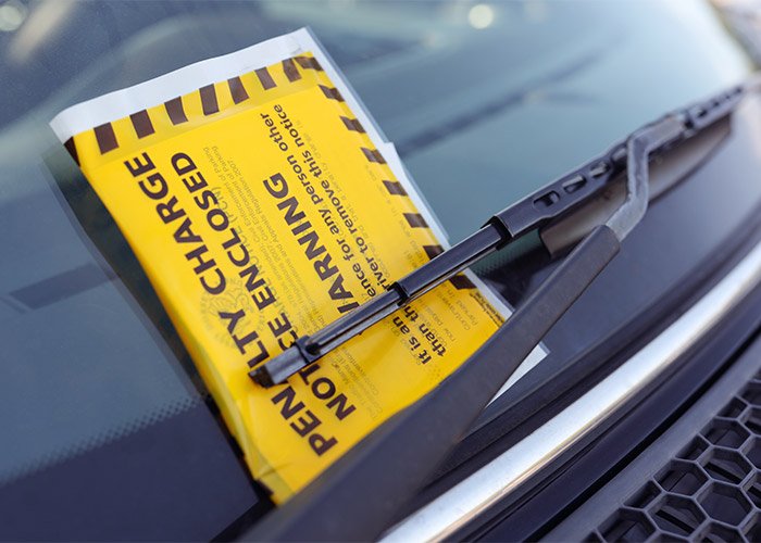 a parking fine attached to a dashboard