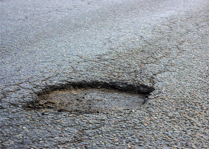 a close up of a pothole on a road