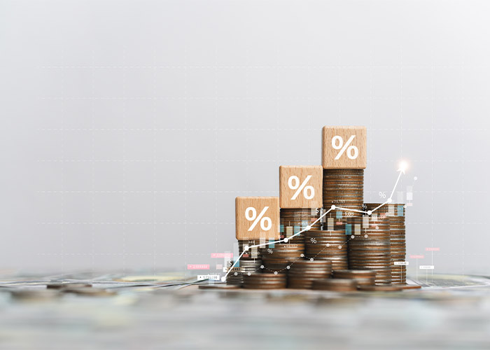 Stack of coins with an up arrow to represent minimum wage and income tax going up