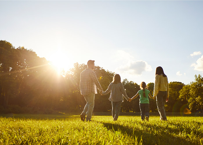 a family walking through a field in the summer